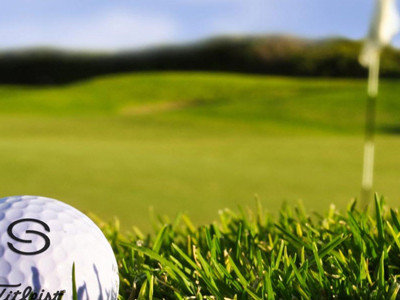 close up of golf ball near hole with flag